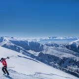 widok na narciarza niosącego narty na ramieniu