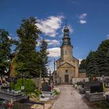 Kościół od strony kruchty z wysoką wieżą, Alejka prowadzi przez cmentarz.